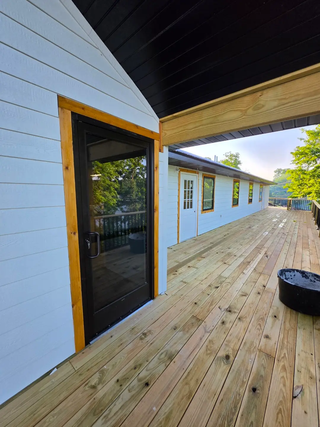 A wooden deck featuring a door, showcasing natural wood grain and a serene outdoor setting.